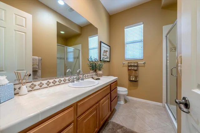 a spacious bathroom with a double vanity sink a mirror and a bathtub