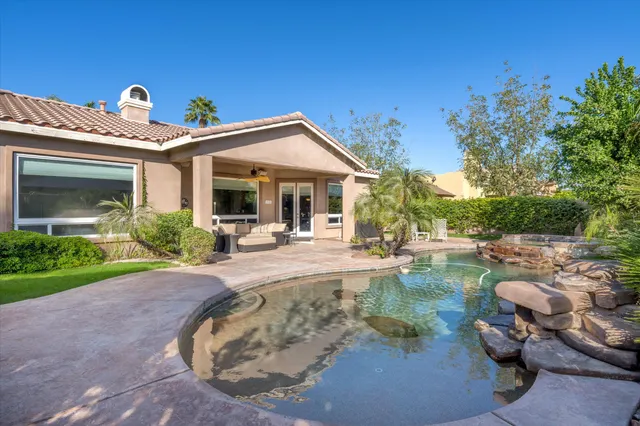 a view of a patio with table and chairs potted plants and palm tree
