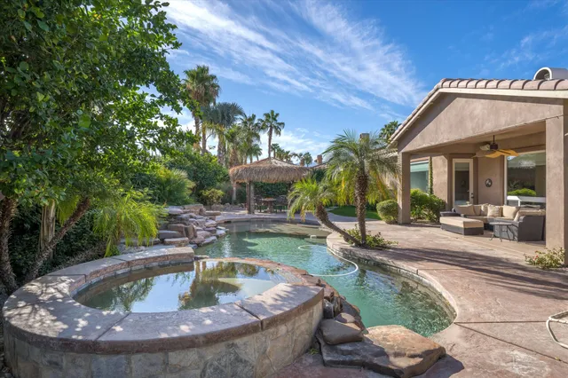 a view of a house with swimming pool and sitting area