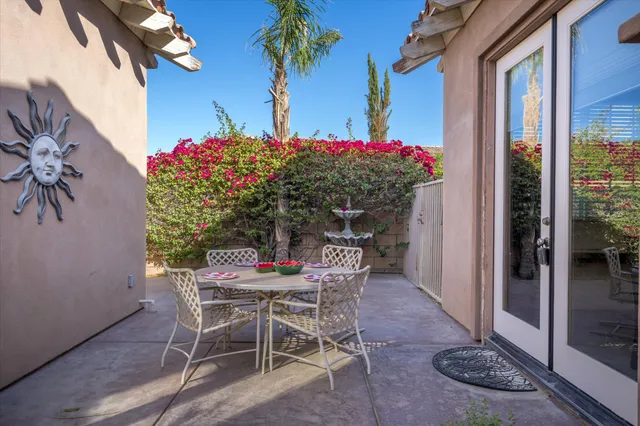 a view of a patio with table and chairs and potted plants