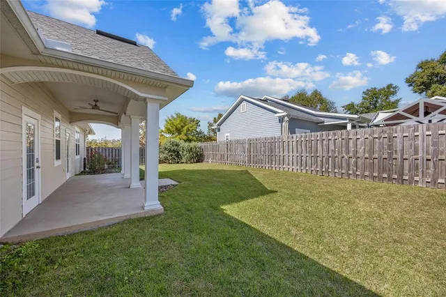 a view of a house with a small yard and wooden fence