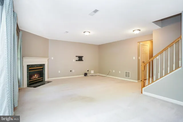 a view of an empty room with a fireplace and a window