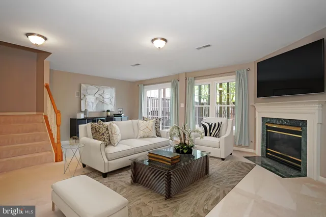 a living room with furniture a flat screen tv and a fireplace