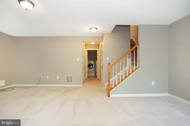 a view of an empty room with staircase