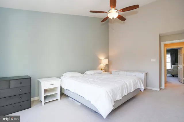 a bedroom with a bed and a ceiling fan