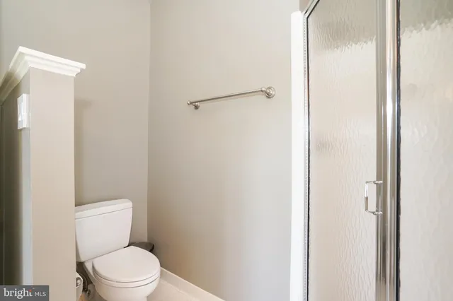 a white toilet sitting next to a shower