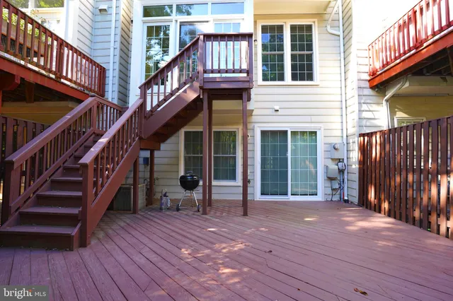 a view of a house with wooden deck stairs and a wooden floor