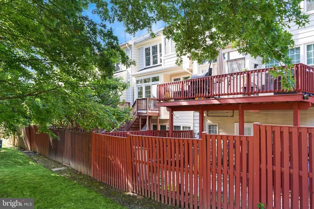 a view of a house with wooden deck and trees