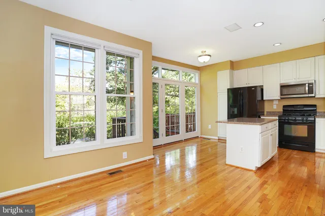 a living room with stainless steel appliances furniture and a large window