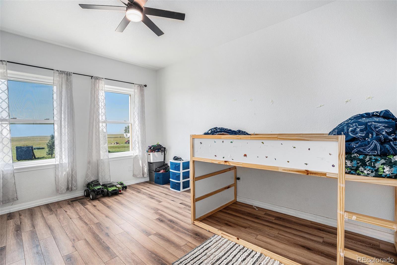 16690 Rabbit Track Trail Colorado Springs, CO 80930 - Photo 18 of 25 a view of a room with wooden floor and ceiling fan