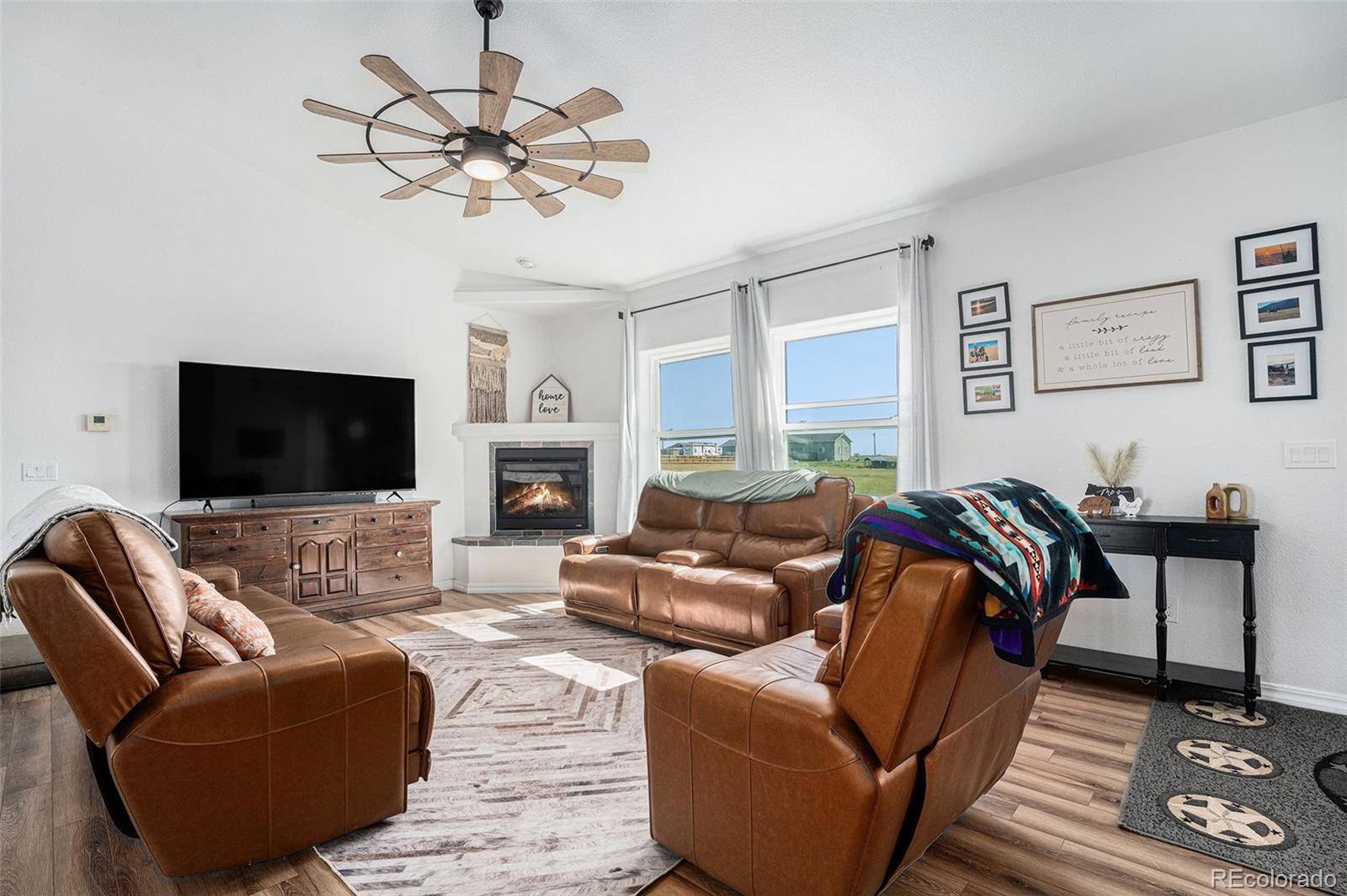16690 Rabbit Track Trail Colorado Springs, CO 80930 - Photo 3 of 25 a living room with furniture a flat screen tv and a fireplace