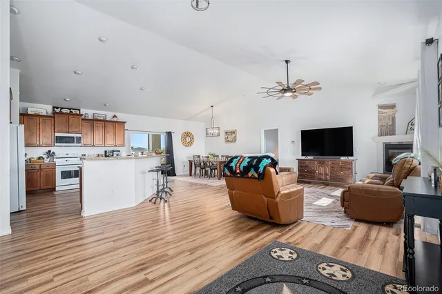 a view of a dining room and kitchen with furniture wooden floor and a rug
