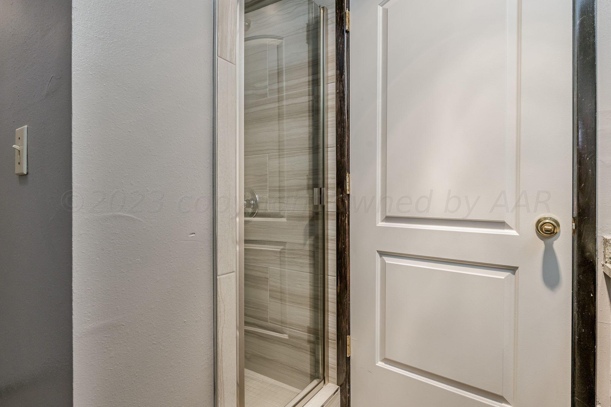 1909 Howard Drive Amarillo, TX 79106 - Photo 12 of 19 a bathroom with a glass shower door