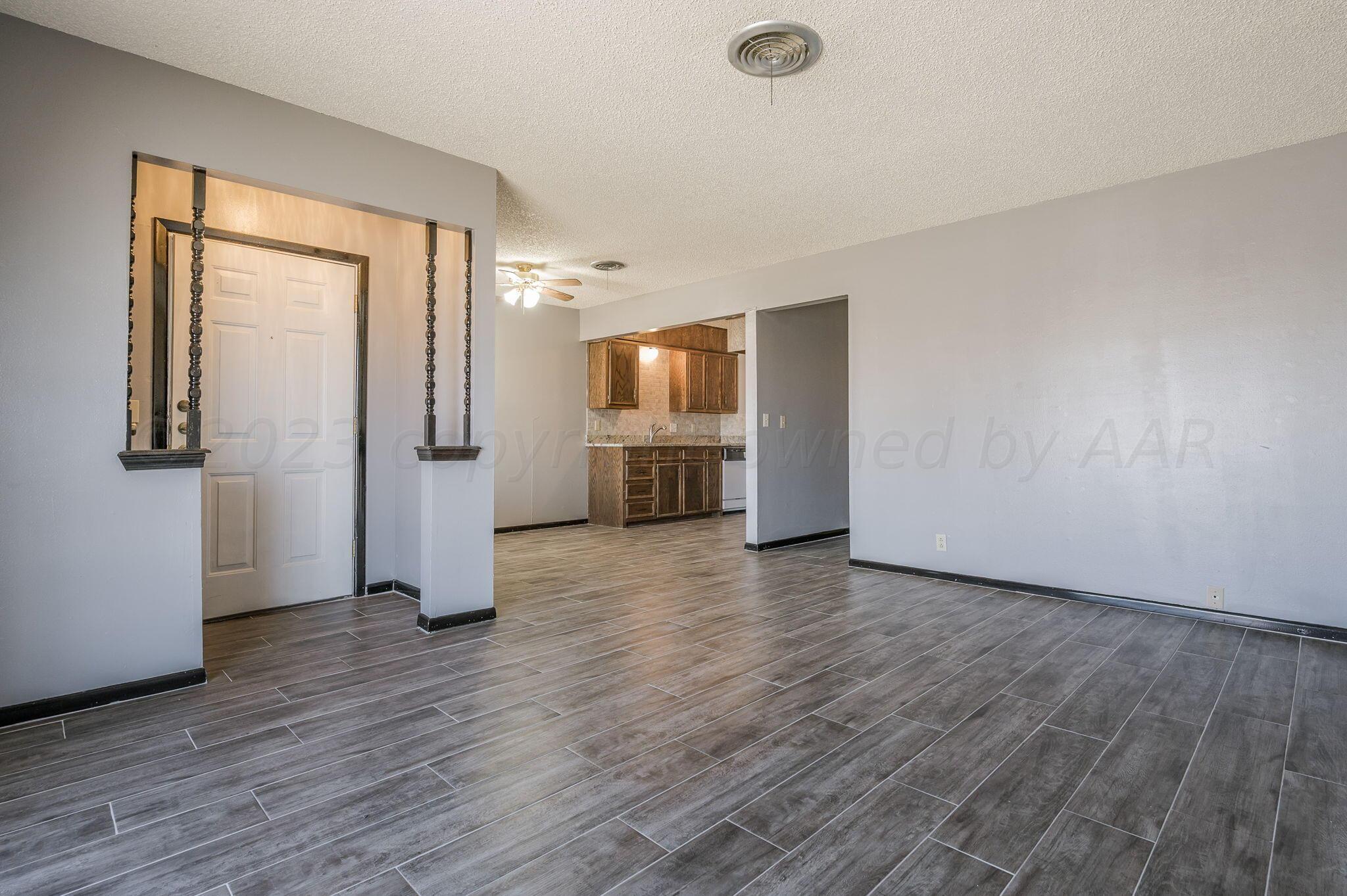 1909 Howard Drive Amarillo, TX 79106 - Photo 3 of 19 an empty room with wooden floor and windows