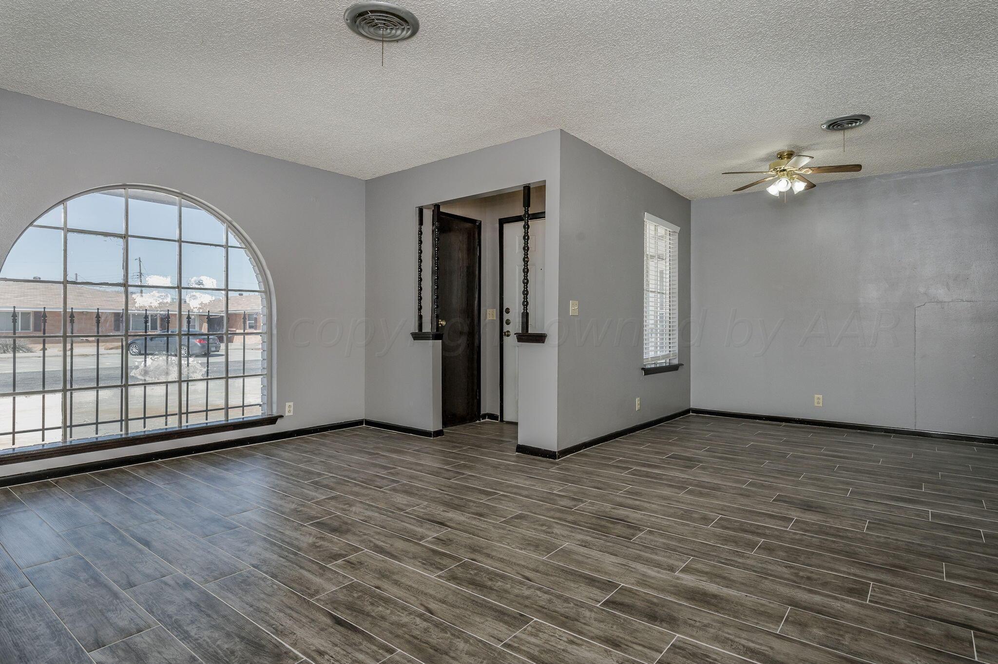 1909 Howard Drive Amarillo, TX 79106 - Photo 5 of 19 an empty room with wooden floor and ceiling fan