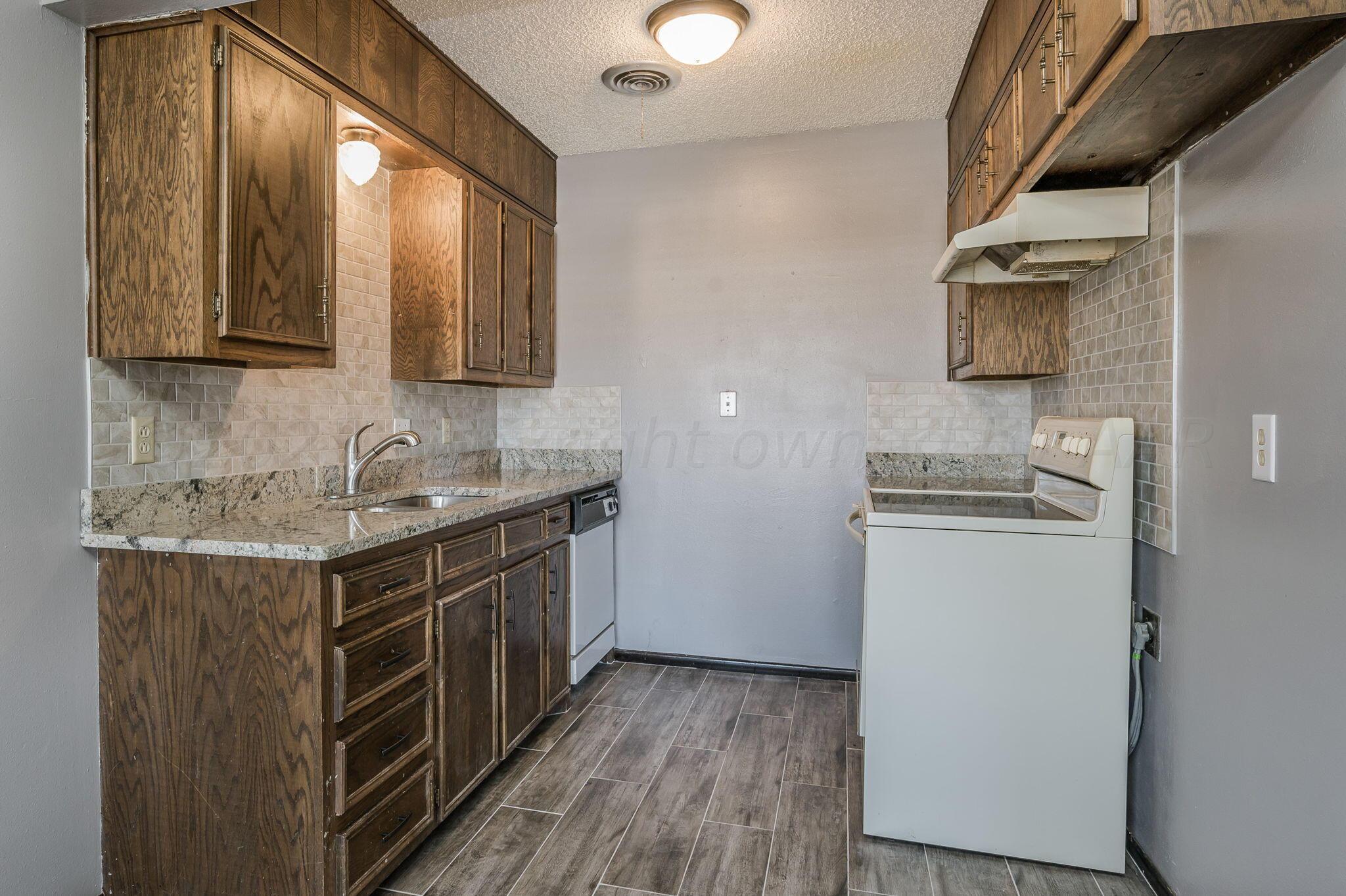 1909 Howard Drive Amarillo, TX 79106 - Photo 6 of 19 a kitchen with a sink cabinets stainless steel appliances and a window
