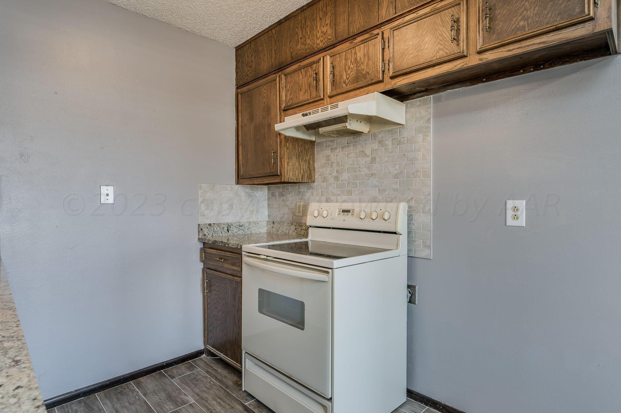 1909 Howard Drive Amarillo, TX 79106 - Photo 7 of 19 a kitchen with stainless steel appliances granite countertop a stove and a refrigerator