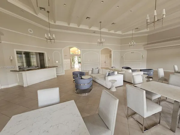 a living room with lots of white furniture and couches