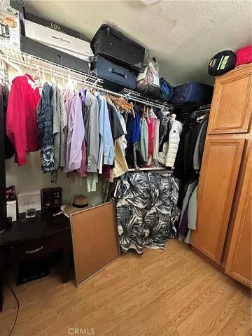a view of walk in closet with clothes and shoes