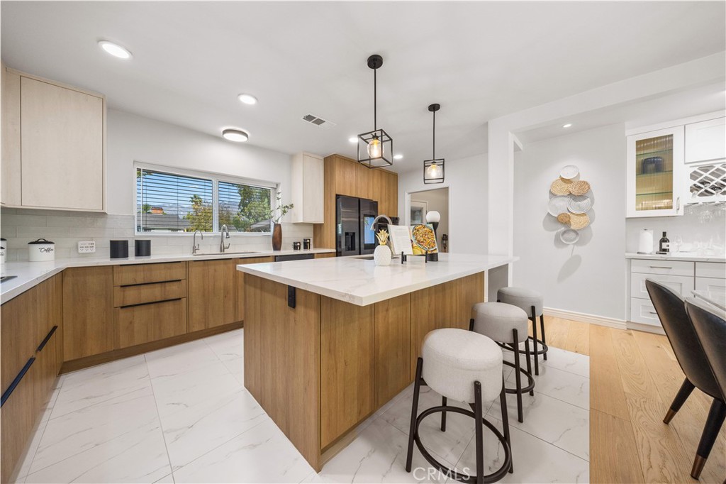 240 Longley Way Arcadia, CA 91007 - Photo 16 of 50 a kitchen with kitchen island a dining table chairs sink and wooden floor