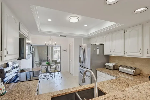 a kitchen with stainless steel appliances granite countertop a sink refrigerator and cabinets
