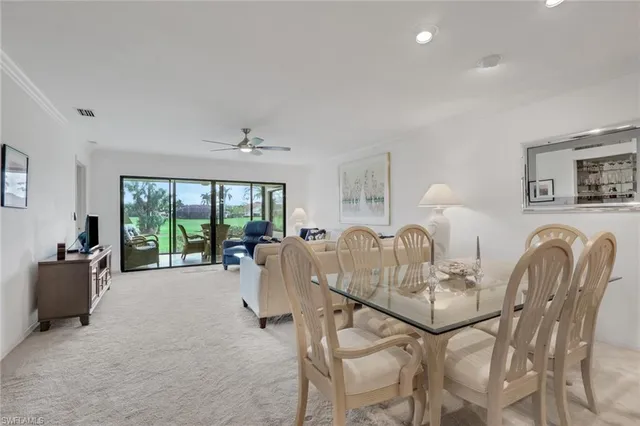 a dining room with furniture and a large window