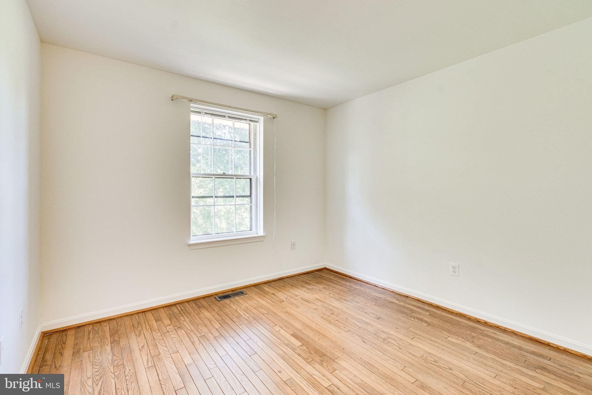 2186 Golf Course Drive Reston, VA 20191 - Photo 11 of 36 an empty room with wooden floor and windows