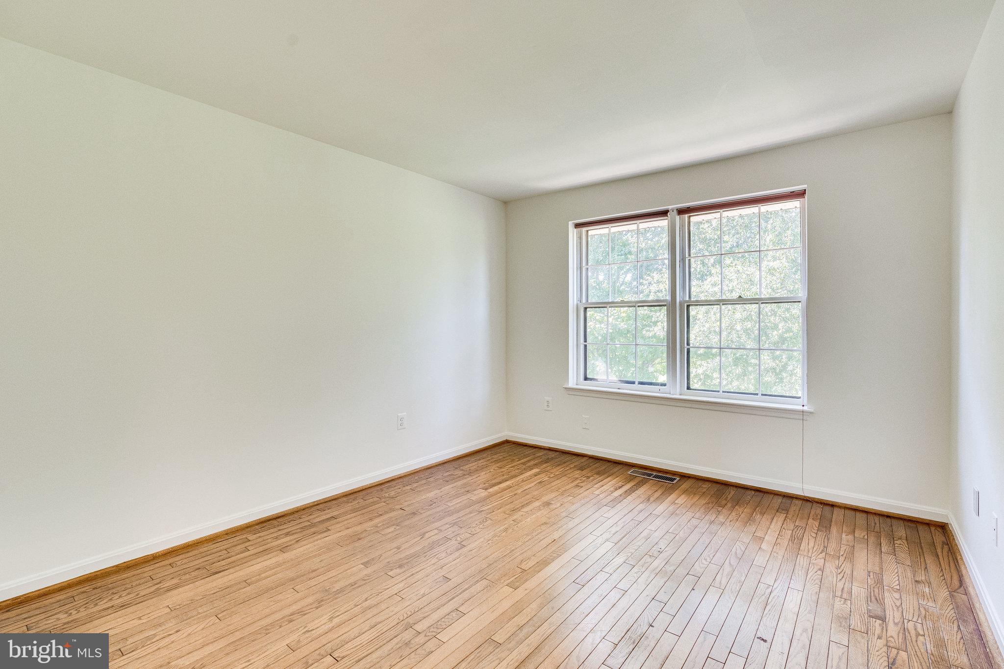 2186 Golf Course Drive Reston, VA 20191 - Photo 12 of 36 an empty room with wooden floor and windows