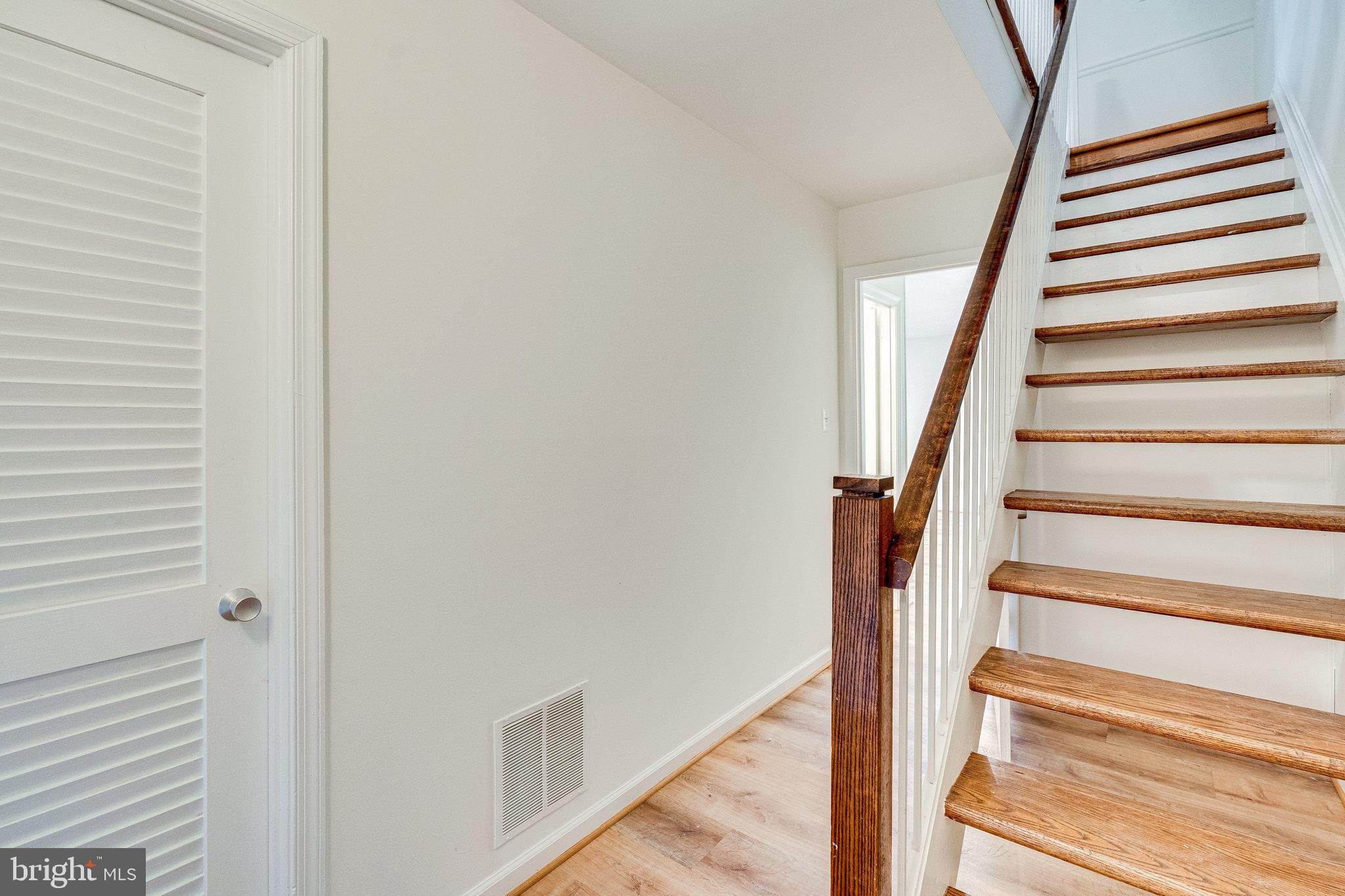 2186 Golf Course Drive Reston, VA 20191 - Photo 19 of 36 a view of staircase with wooden floor and white walls