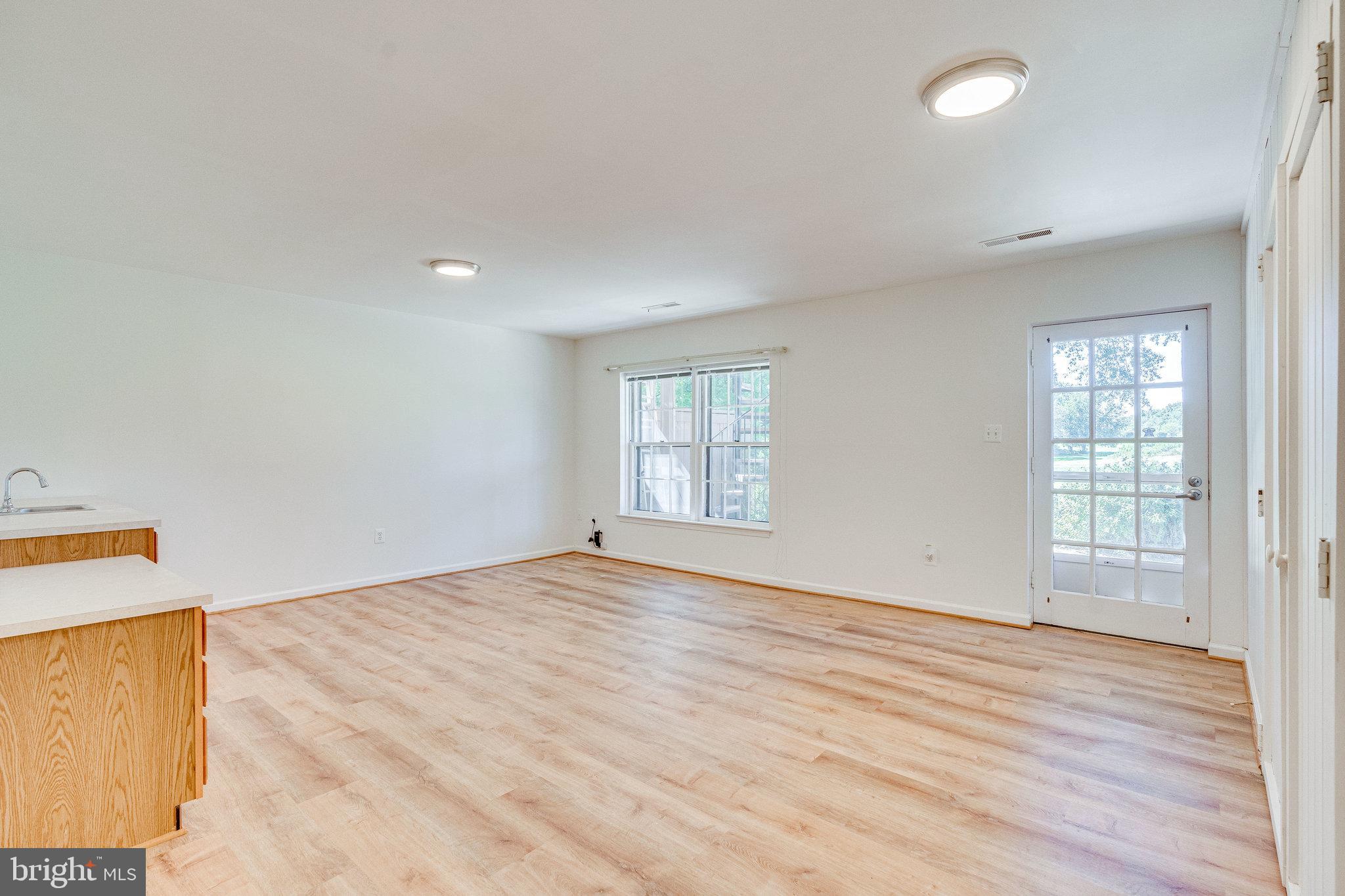 2186 Golf Course Drive Reston, VA 20191 - Photo 21 of 36 an empty room with wooden floor and windows