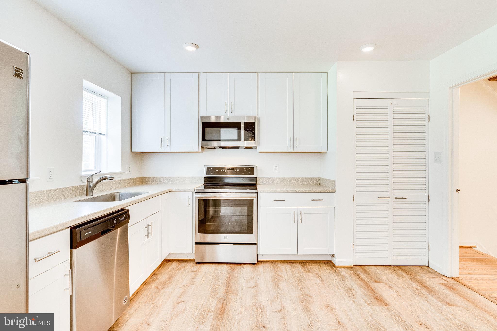 2186 Golf Course Drive Reston, VA 20191 - Photo 7 of 36 a kitchen with a sink a stove a microwave and cabinets