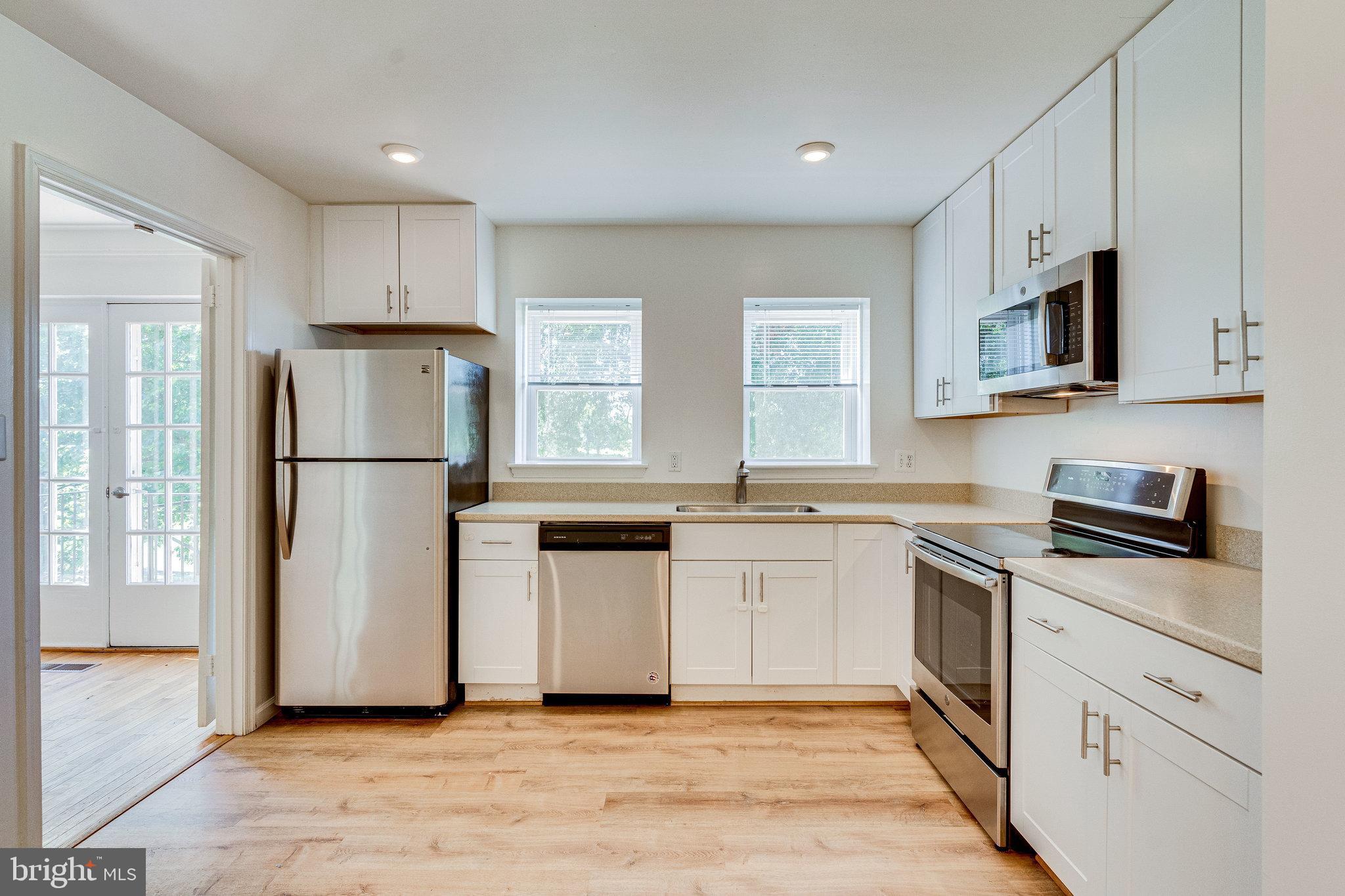 2186 Golf Course Drive Reston, VA 20191 - Photo 8 of 36 a kitchen with white cabinets white stainless steel appliances and sink