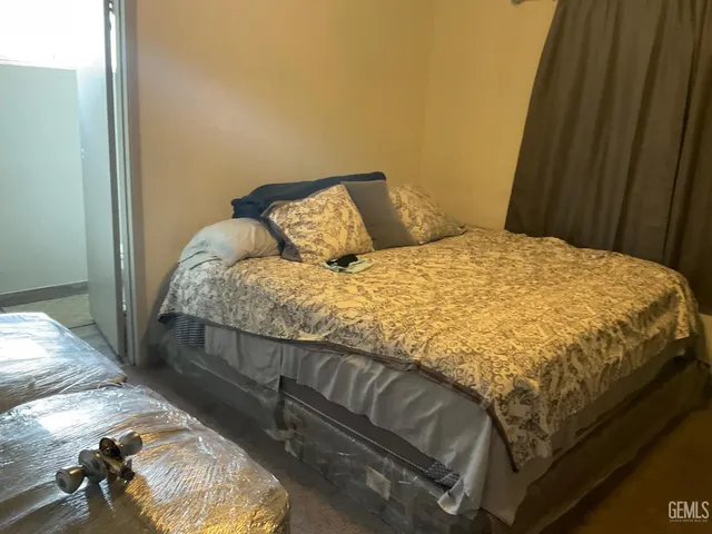 a bed sitting in a bedroom next to a window