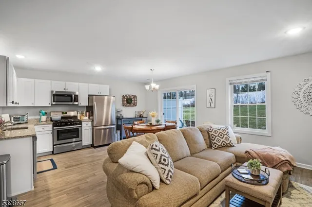 a living room with furniture flat screen tv and window