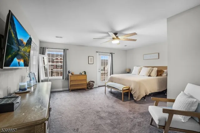 a spacious bedroom with a bed a couch and a potted plant