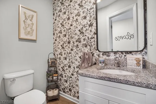 a bathroom with a granite countertop toilet and a sink