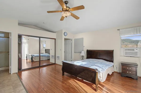 a bedroom with a large bed a chandelier and a window