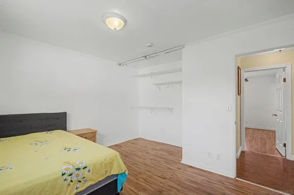 a bedroom with a bed and wooden floor