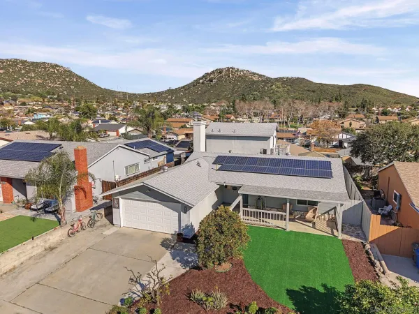 an aerial view of a house with a mountain