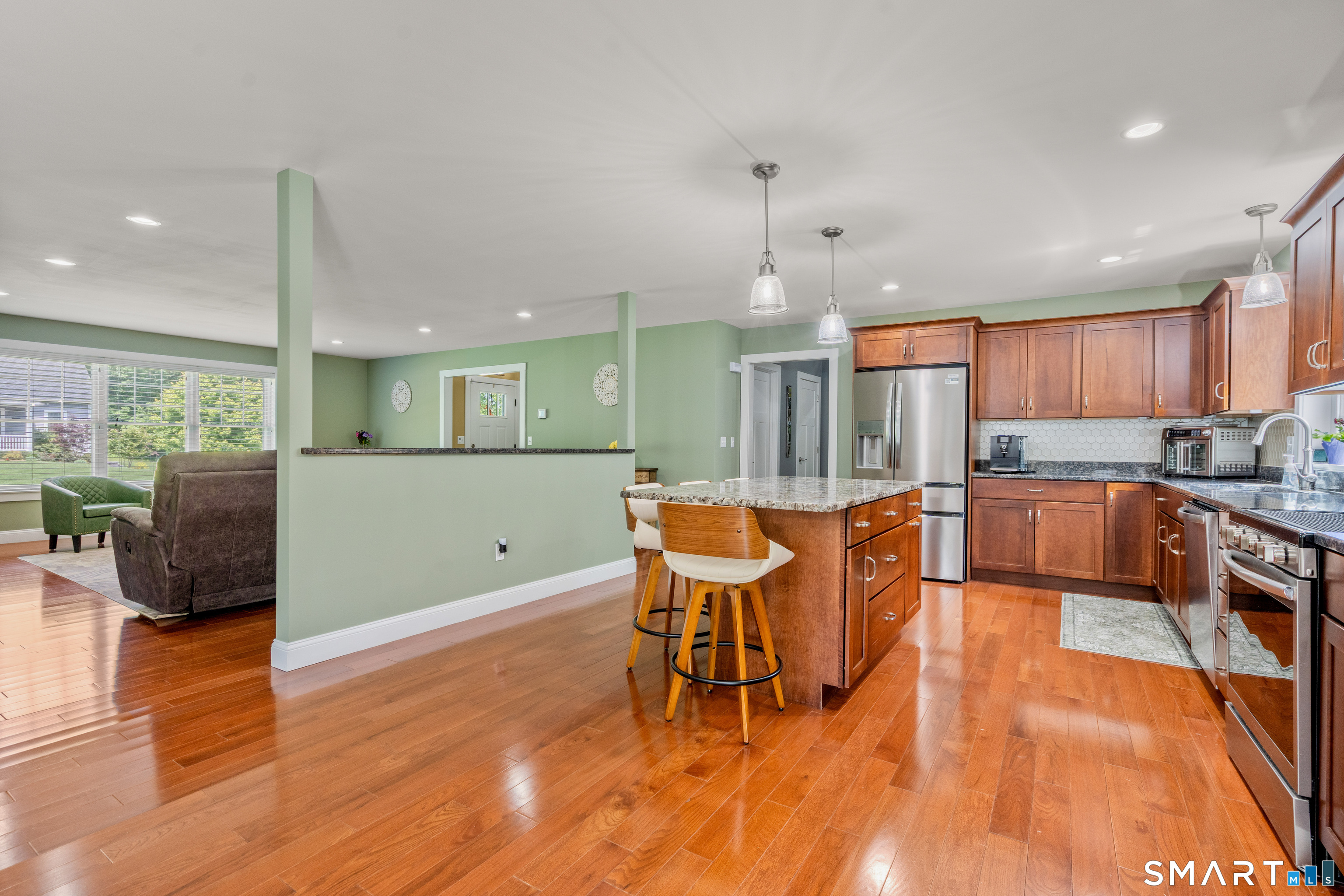 5 Limric Lane Suffield, CT 06078 - Photo 10 of 36 a large kitchen with stainless steel appliances kitchen island granite countertop a large kitchen island a stove a refrigerator a sink a dining table and chairs with wooden floor