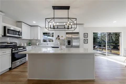 a view of a kitchen counter space a sink and wooden floor