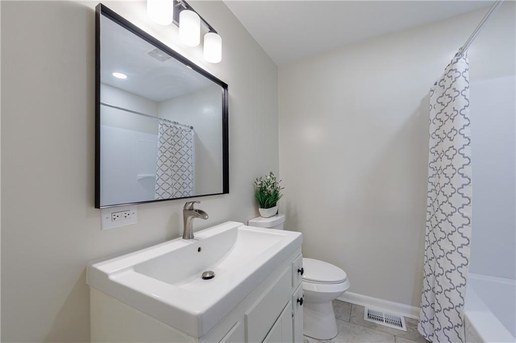 2996 Arrowood Drive East Point, GA 30344 - Photo 31 of 63 a bathroom with a toilet sink and mirror