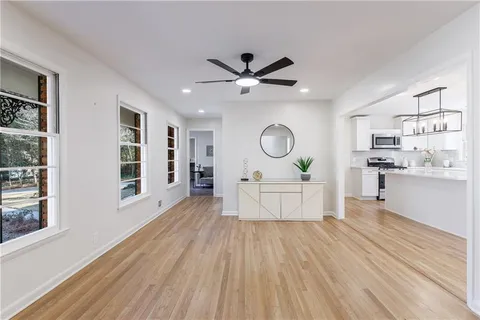 a view of an empty room with window and wooden floor