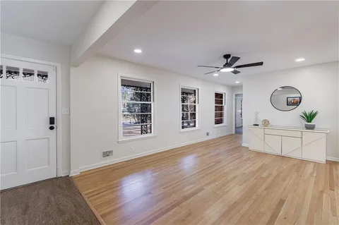 a view of an empty room with window and wooden floor