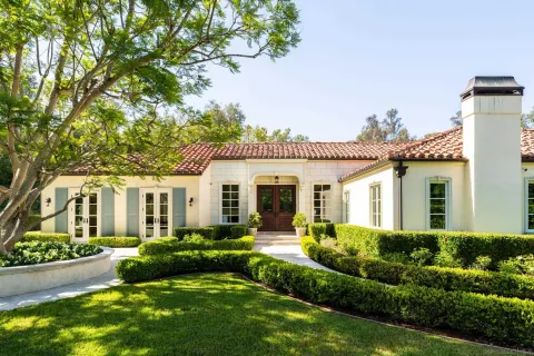 a front view of a house with a yard and potted plants