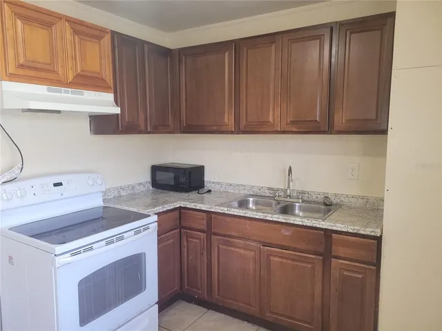 a kitchen with a sink stove and cabinets