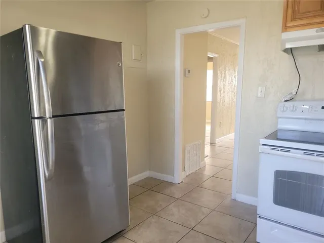 a white refrigerator freezer and a stove in a kitchen