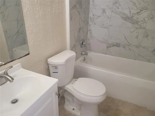 a white toilet sitting next to a bath tub