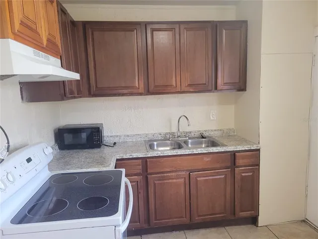 a kitchen with stainless steel appliances granite countertop a sink a stove and washer
