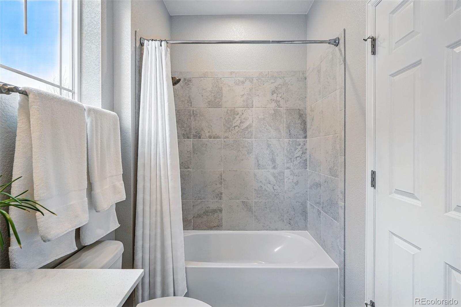 745 Penstemon Drive Henderson, CO 80640 - Photo 22 of 38 a bathroom with a bathtub and a shower